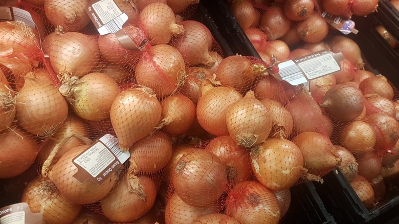 Bagged brown onions in crates at Aldi