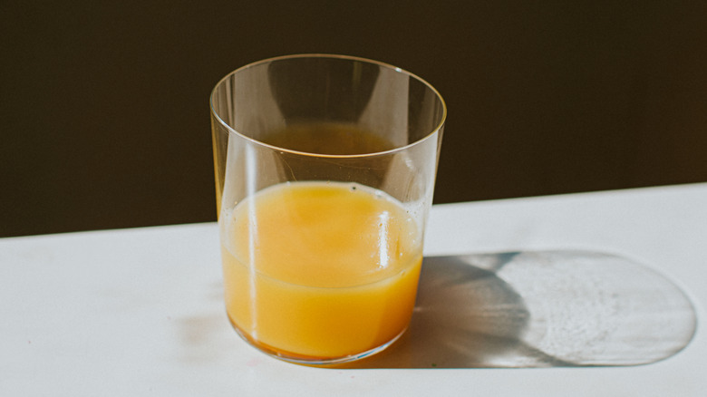 Glass of orange juice on counter