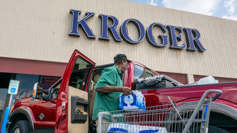 Man loading car with shopping in front of Kroger store