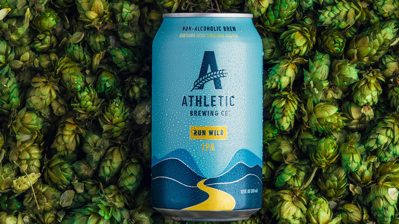 Athletic Brewing Run Wild IPA on a backdrop of hops