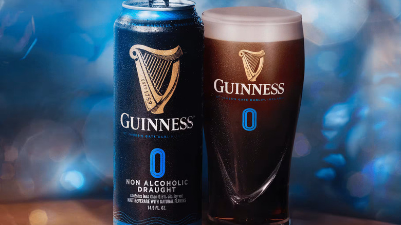 Guinness 0 in a can and a pint, against an iridescent blue backdrop