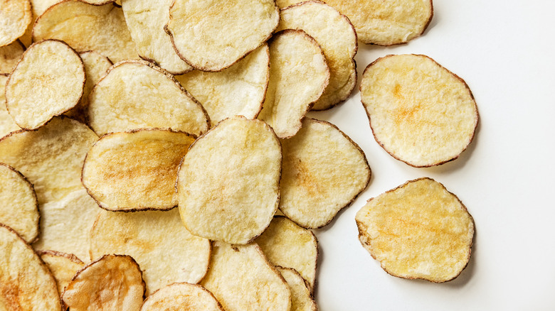 Homemade potato chips on white surface