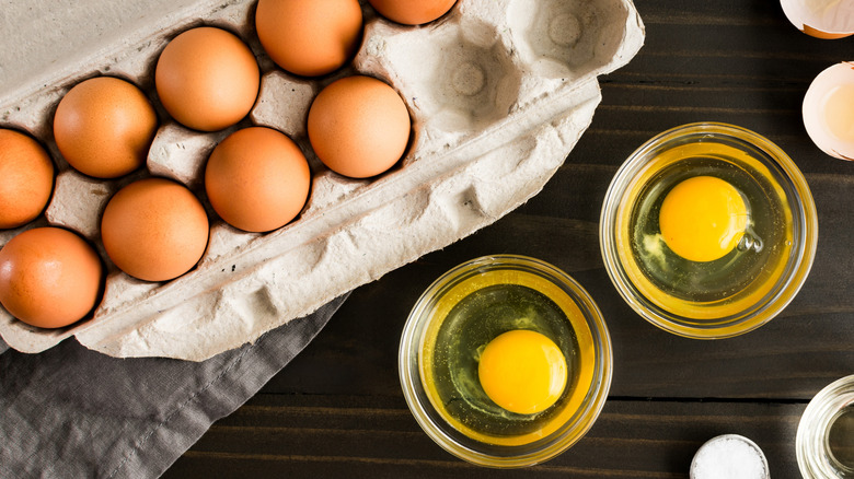 Egg carton with raw egg in ramekin