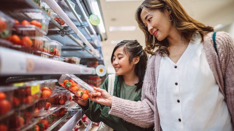 Family members buying strawberries at store