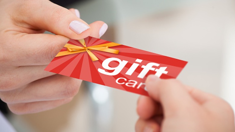 Person handing another person a gift card