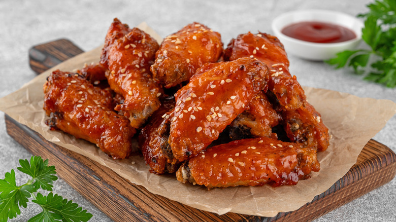 Chicken wings in sauce on a wooden board