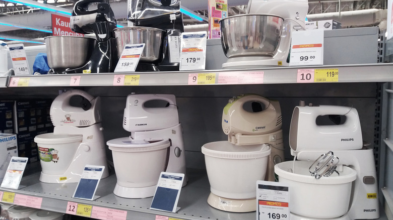 Various types of electrical stand mixer arranged on shelves