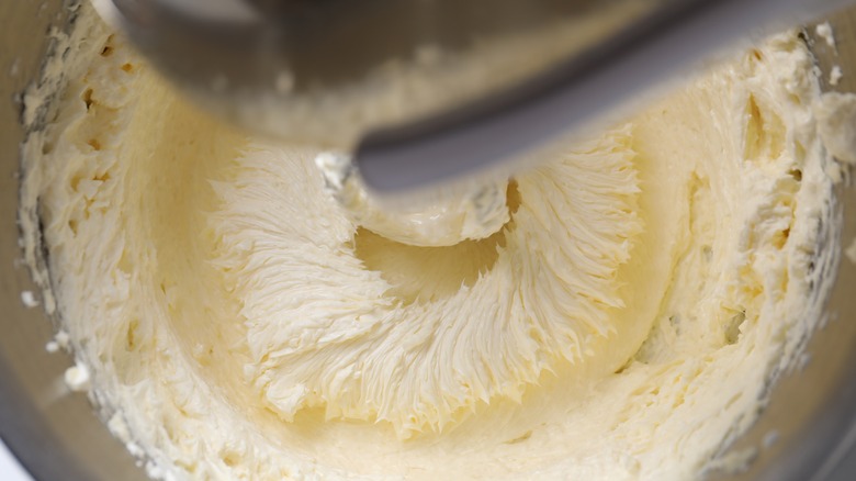 Mixing whipped cream in bowl with stand mixer, top view