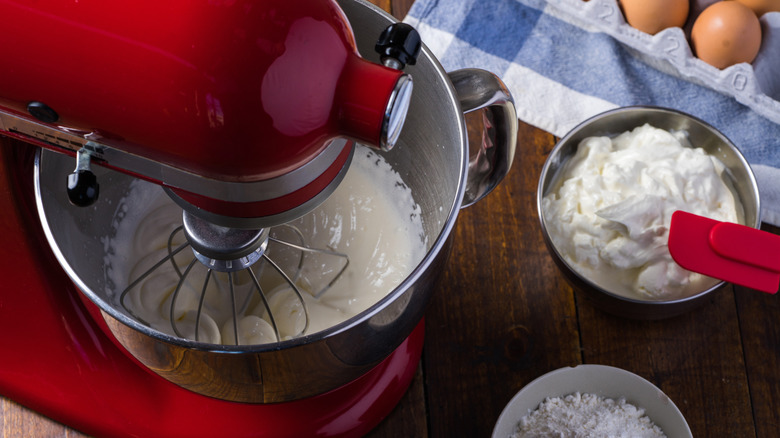 Standing mixer on wooden table with ingredients