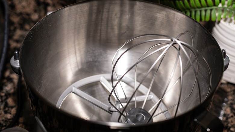 Stainless steel stand mixer bowl with a wire whisk attachment