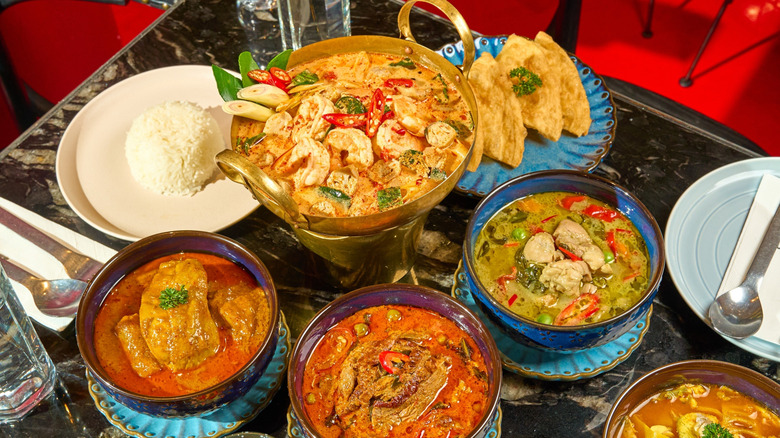 Bowls of Thai sour curry with sea bass served with steamed jasmine rice