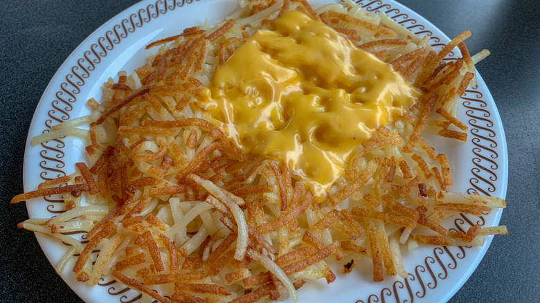 plate of hash browns covered in melted cheese