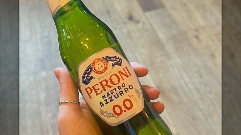 Hand holding a bottle of Peroni 0.0