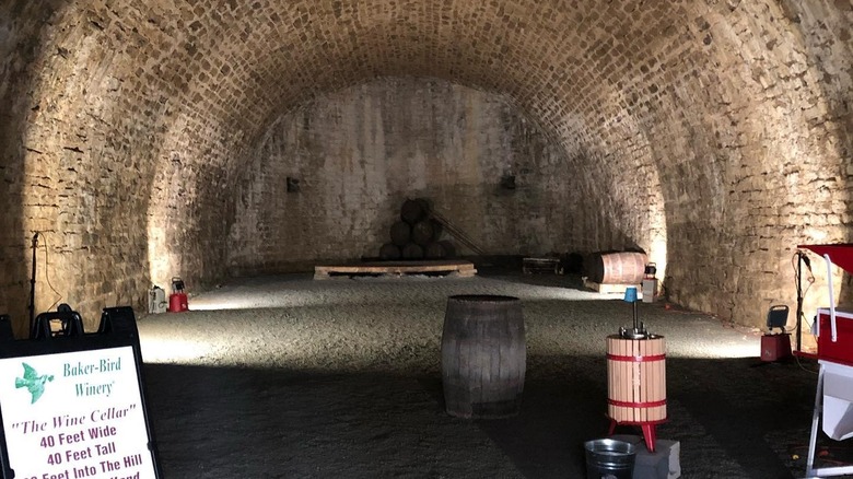 wine cave with a sign, barrel, and press
