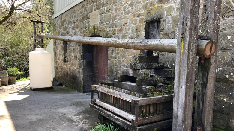 stone building with wooden press in front