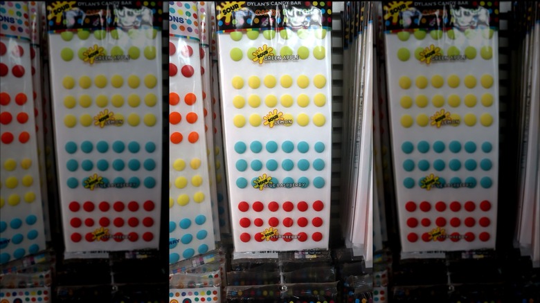 Packs of candy buttons hanging in a store display