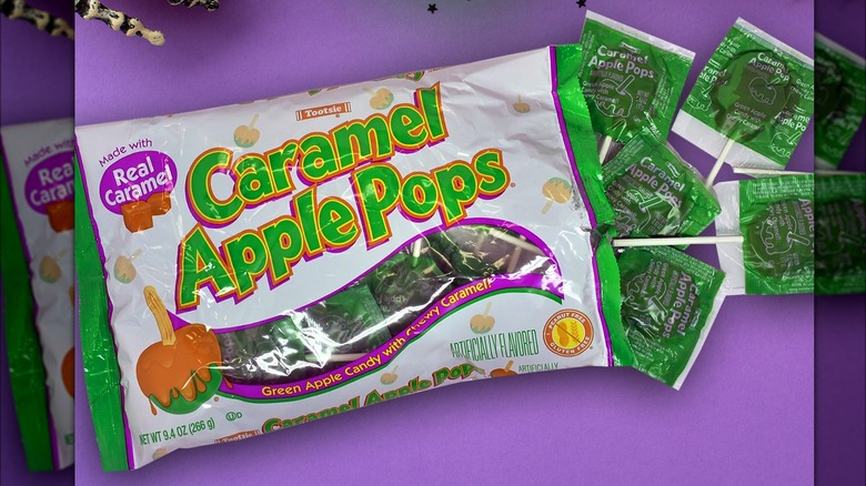Bag of caramel apple pops on purple background