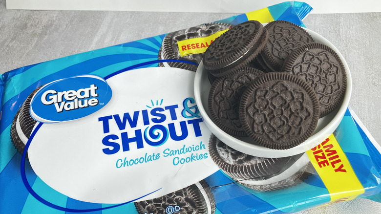 Great Value Twist and Shout chocolate sandwich cookies fill a small white dish sitting on top of a blue cookie package