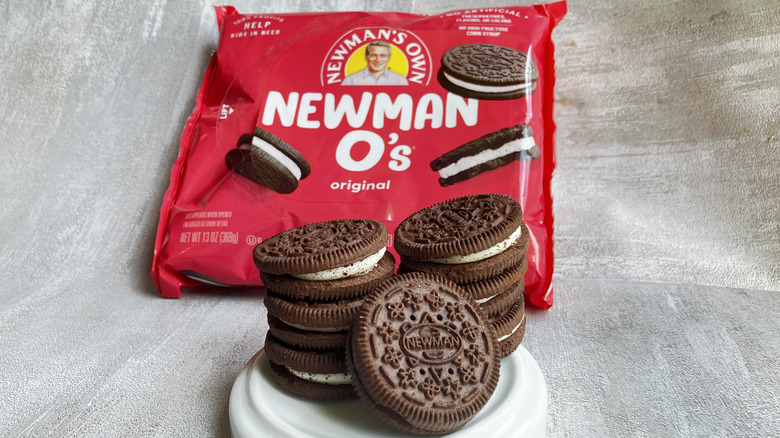 Stacks of Newman O's chocolate sandwich cookies in a small white dish with a red package of cookies in the background.