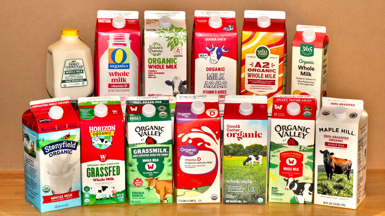 A selection of 13 different organic milks in their cartons and stacked on a table