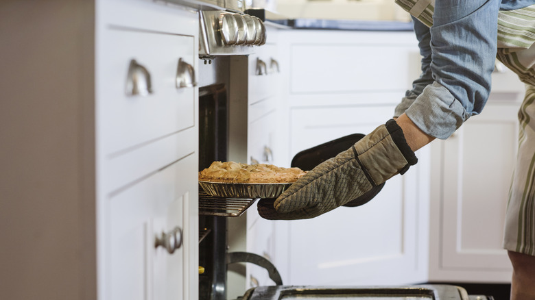 Woman placing food inside an oven