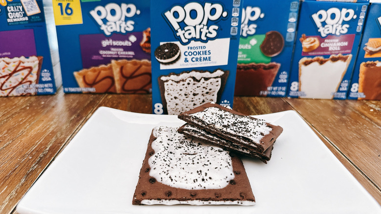Frosted cookies and crème pop tart cut on a plate with package in background