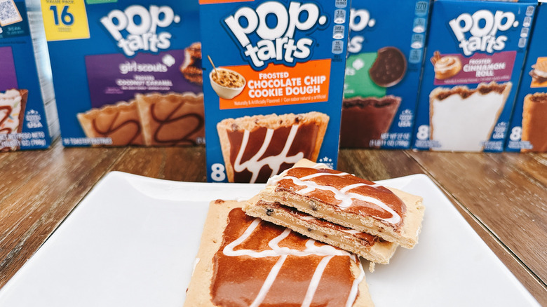 Frosted Chocolate chip cookie dough Pop-Tart cut on a plate with package in background