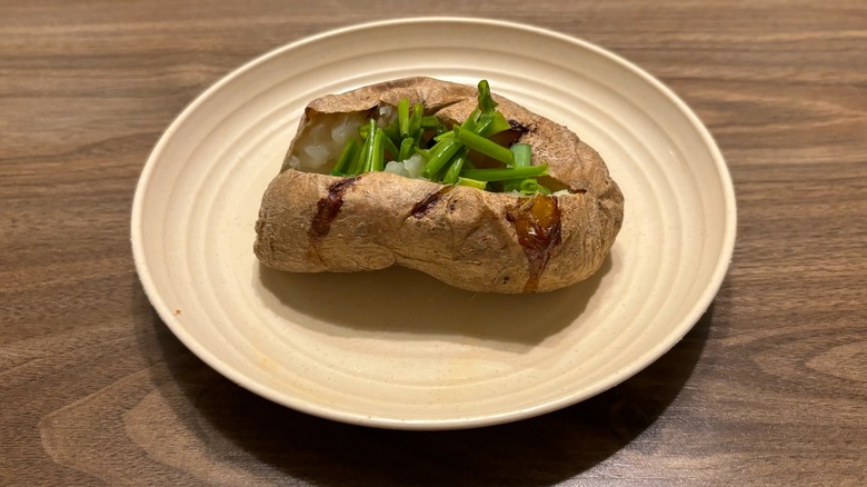 baked potato with chives on plate