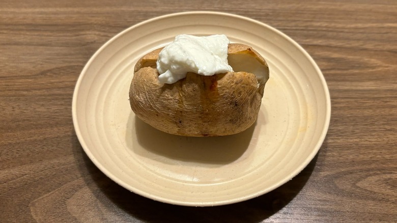 baked potato with dollop of Greek yogurt on plate