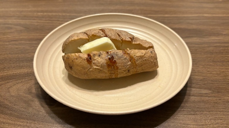 baked potato with slab of butter on plate