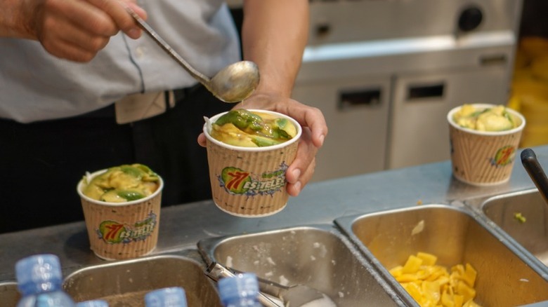 aAworker serves a cup of food at Es Teler 77 restaurant