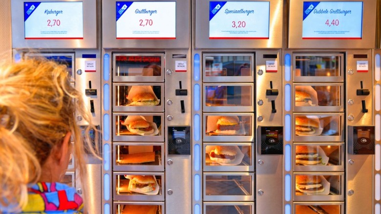 A woman looks at burgers inside vending machines at FEBO