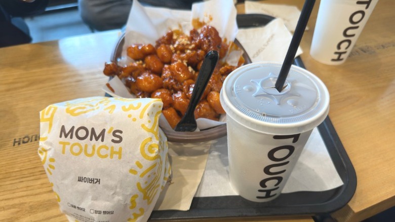 Wrapped burger, drink, and basket of saucy chicken from Mom's Touch restaurant in South Korea