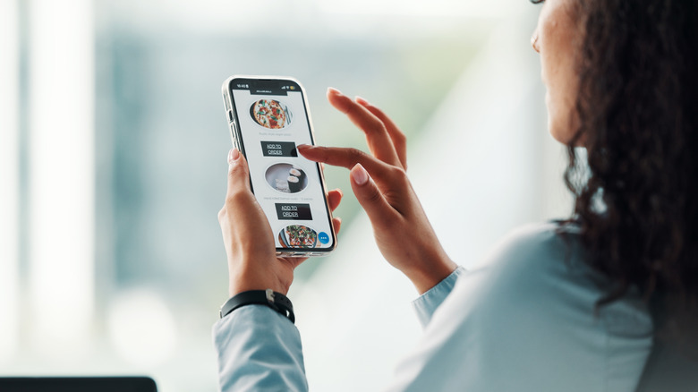 A woman scrolling through a food app.
