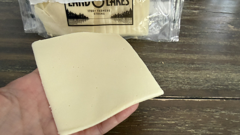 Hand holding a slice of Land O Lakes White American