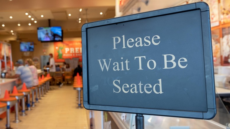 A 'Please wait to be seated' sign is displayed at the entrance to Preps Pizzeria & Dairy Bar in Ocean City, New Jersey