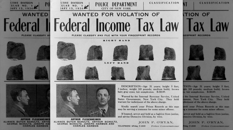 A 1934 "Wanted" poster for Dutch Schultz that reads, "Wanted for Violation of Federal Income Tax Law" with his fingerprints in two rows underneatth it and his side- and front-view photos on the bottom left and description of him on bottom right