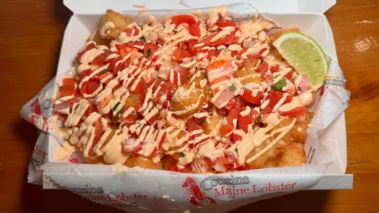 A plate of "lobster tots": tater tots covered with lobster, cilantro lime sauce and pico de gallo.