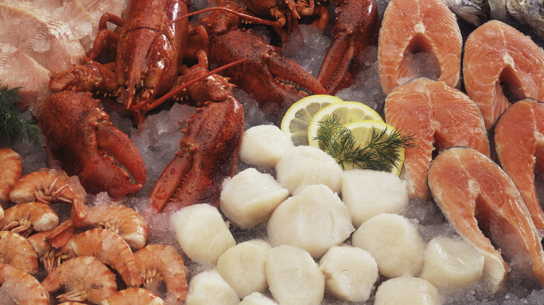A seafood buffet with lobsters, shrimp, scallops and fish fillets.