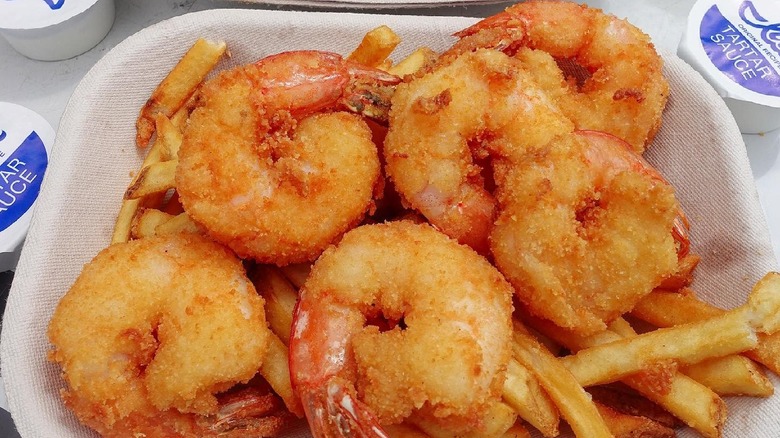 A platter of Ivar's Seafood Bar fried shrimp over a bed of fries.