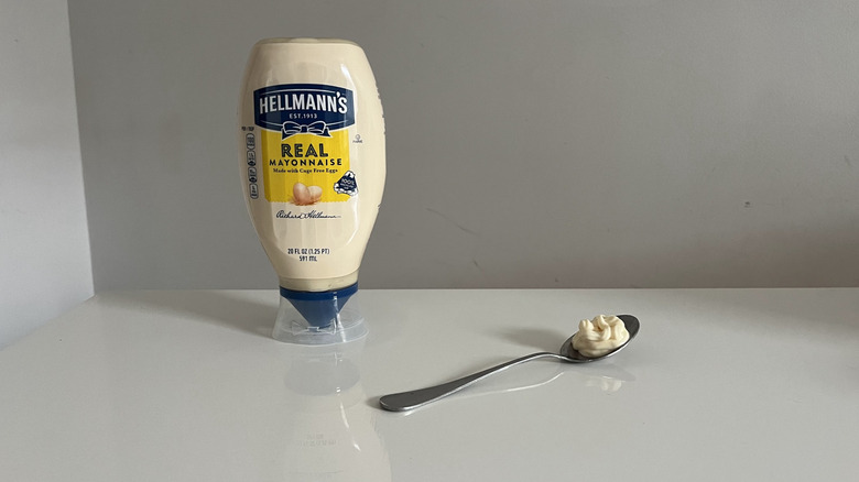 A squeeze bottle of Hellmann's mayonnaise on a white surface