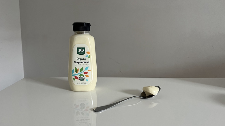 A small jar of 365 Organic mayonnaise sitting next to a spoon