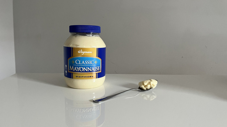 A large jar of Wegmans mayonnaise next to a spoon