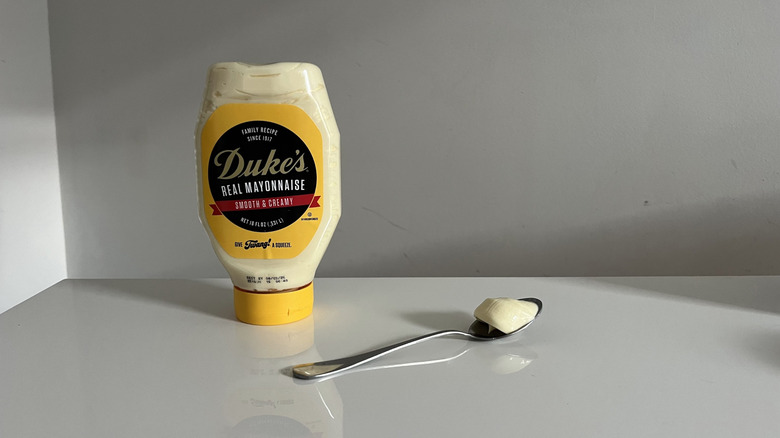 A container of Duke's mayonnaise with a bit squirted out into a spoon