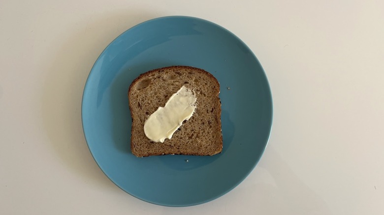 A piece of bread with a swipe of mayonnaise