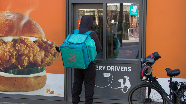 A food delivery driver waiting outside a Popeyes