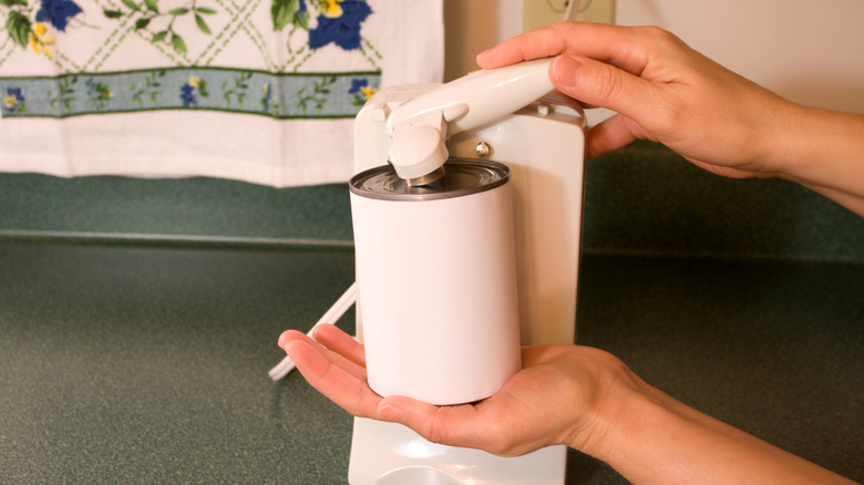 A white electric can opener and a white can
