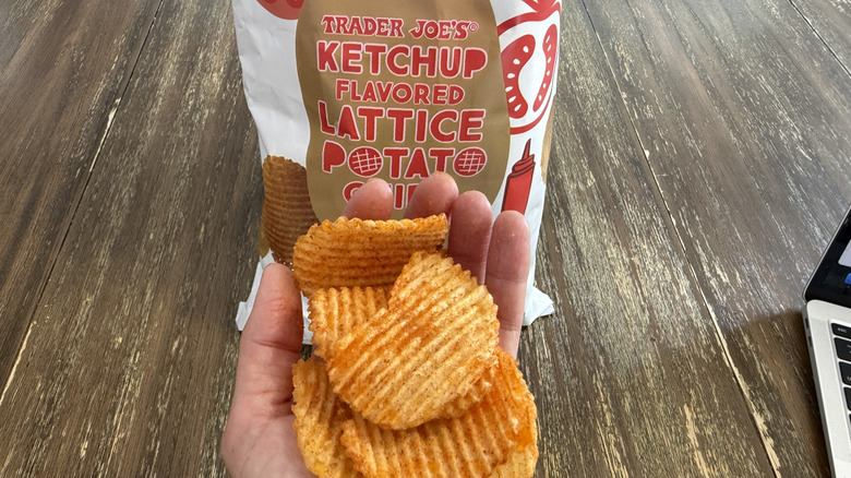 Trader Joe's Ketchup Flavored Lattice Potato Chips on wooden table and a handful of them