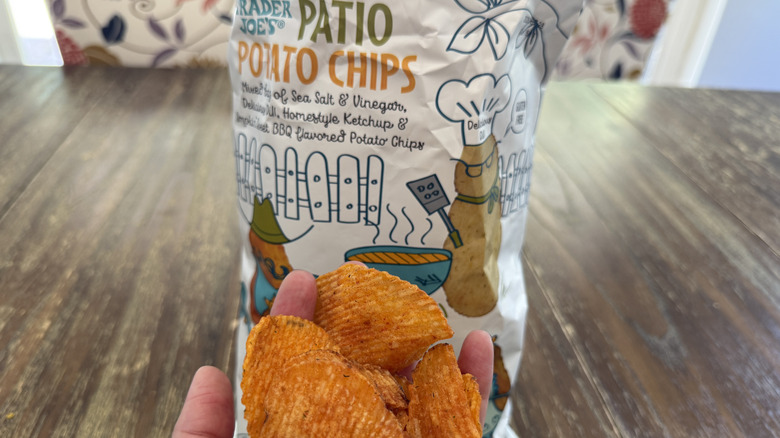 Trader Joe's Patio Potato Chips on wooden table and a handful of them