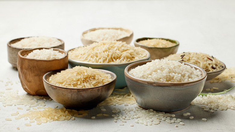 Bowls of different types of rice on a white surface
